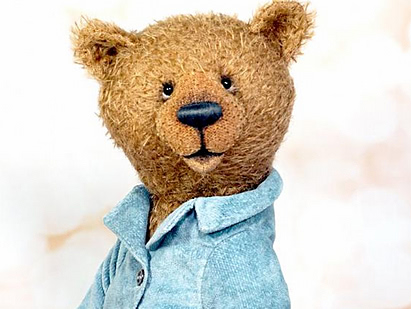 Улыбающийся мишка Тедди в голубом шарфе