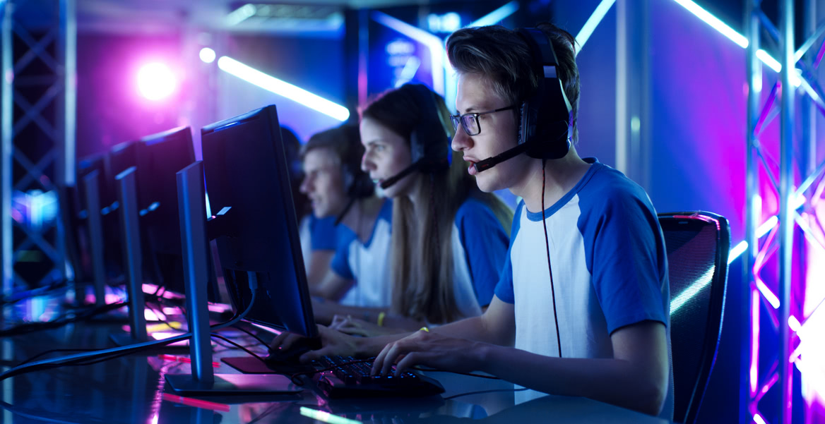 Команда подростков играет в  компьютерную игру на киберспортивном турнире