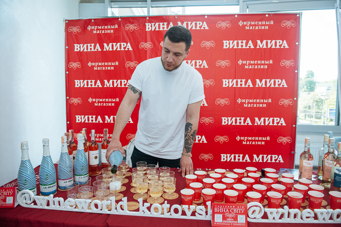 Мужчина наливает вино Вина Мира